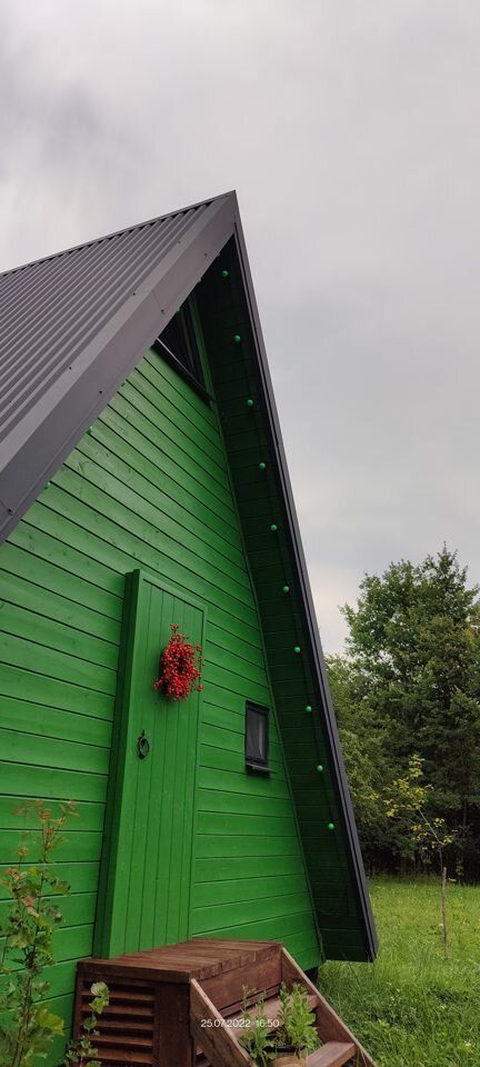 Дом A-frame в окружении леса.