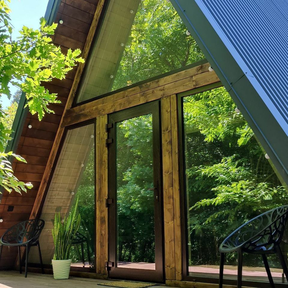 Дом A-frame в окружении леса.